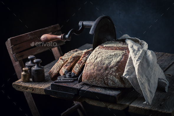 Homemade loaf of bread on old slicer