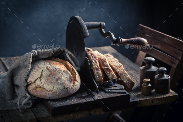 Healthy loaf of bread on old slicer