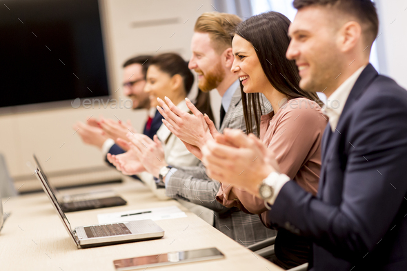 Happy smiling business team clapping hands Stock Photo by BGStock72