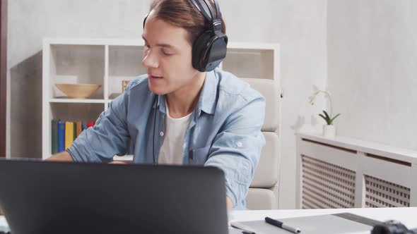 Workplace of freelance worker at home office. Young man works using computer. alt
