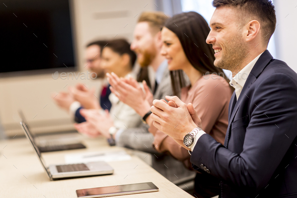 Happy smiling business team clapping hands Stock Photo by BGStock72