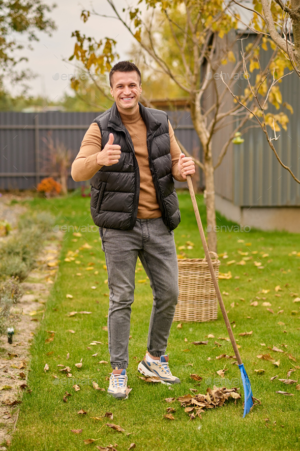 Man standing with rake showing ok gesture