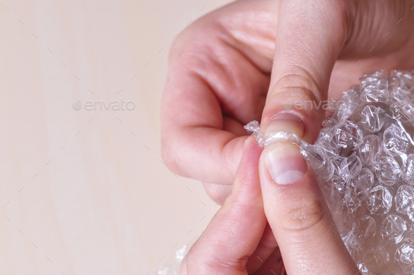 Stress concept. Woman's hands popping bubbles from a bubble paper. - Stock Photo - Images