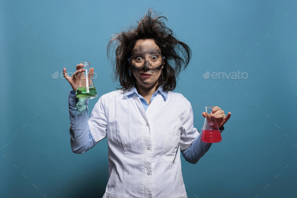 Crazy looking chemist holding Erlenmeyer glass jars filled with unknown chemical compounds while on