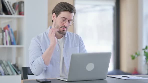 Man in Glasses with Laptop Having Neck Pain alt