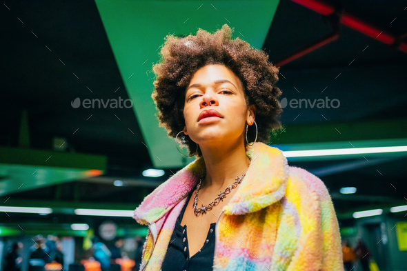 Portrait young curly hair fashionable and confident black woman indoor looking camera