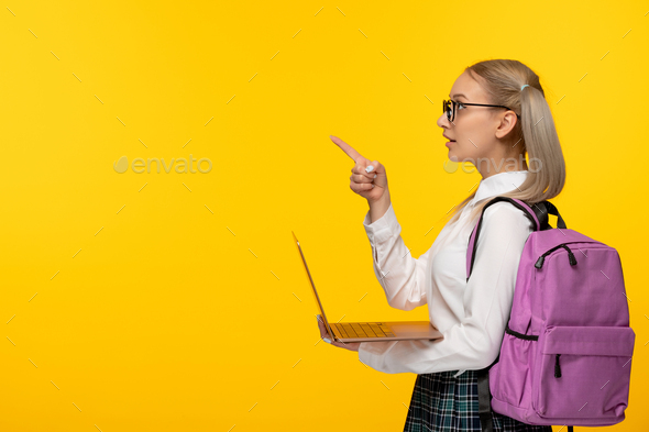 world book day smart student in uniform with pink backpack holding a laptop computer
