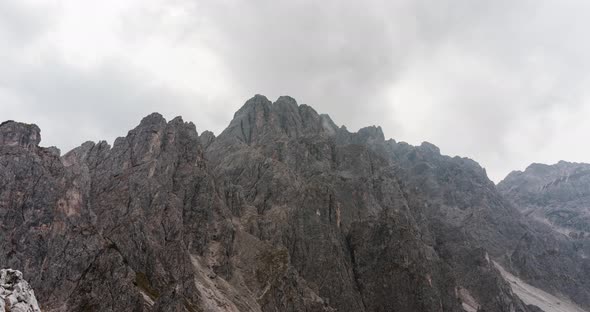 Timelapse of clouds moving above a rocky mountain range in the italien dolomites alt