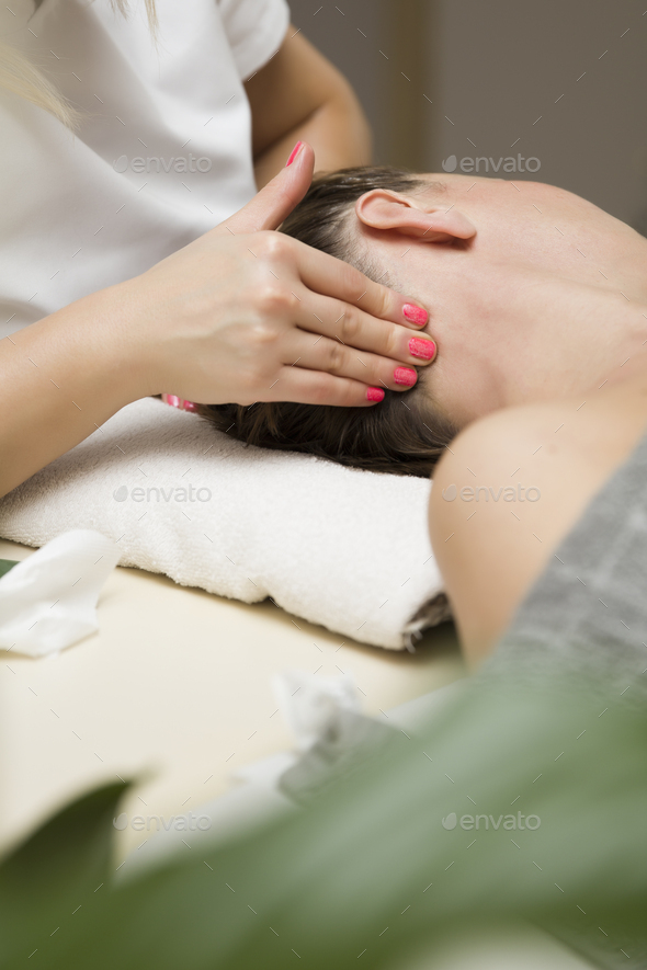 Woman getting a stress relieving pressure point massage on her neck by a health therapist