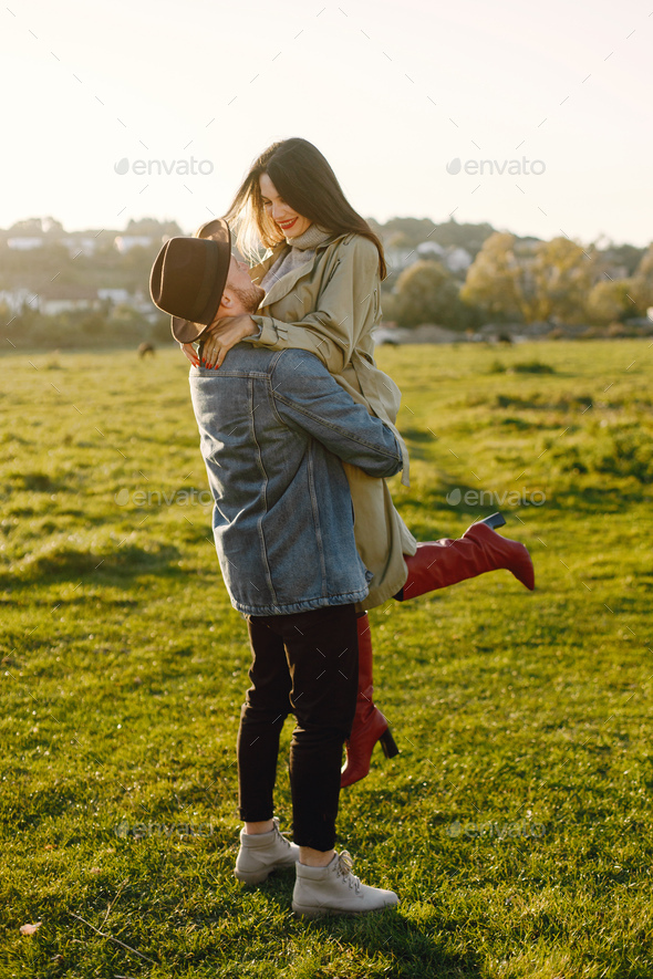 Stylish romantic couple walking in a field and posing for a photo - Stock Photo - Images