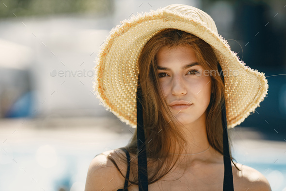 Portrait of a young girl in a swimwear standing near pool - Stock Photo - Images