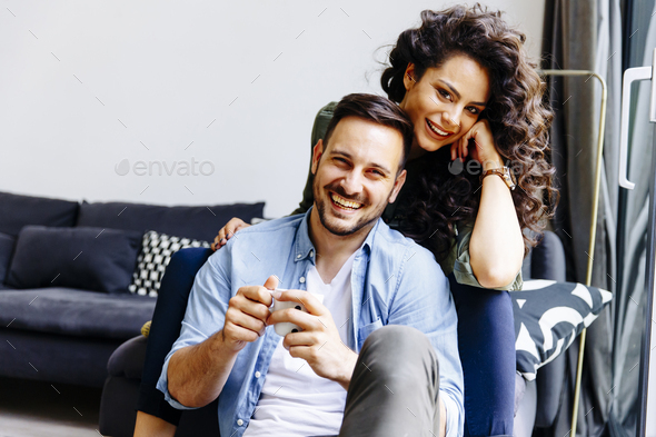 Happy Cute Couple In Love Embracing Each Other And Drinking Coffee