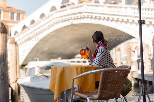 Woman rest at outdoor cafe on Grand Canal, traveling Venice