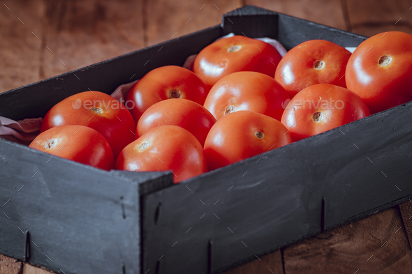Black wooden box with red tomatoes of the roma variety. - Stock Photo - Images