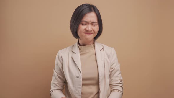 Asian business woman angry and screaming isolated over beige background. 4K video