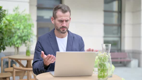 Man Reacting to Loss While Using Laptop Outdoor alt