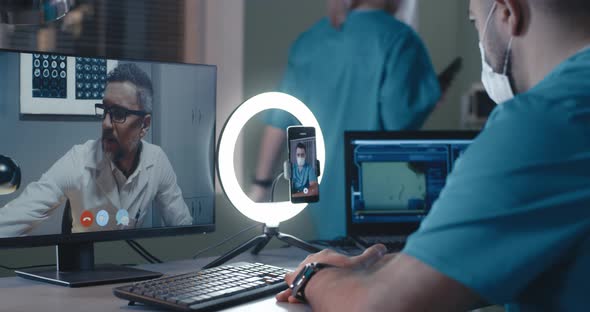 Male Doctor Discussing X Ray Scan with Online Colleague During Pandemic alt