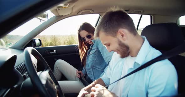 Couple Fastening Seat Belts