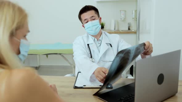 Young Man Doctor in a White Coat Communicates with Patients Portrait alt