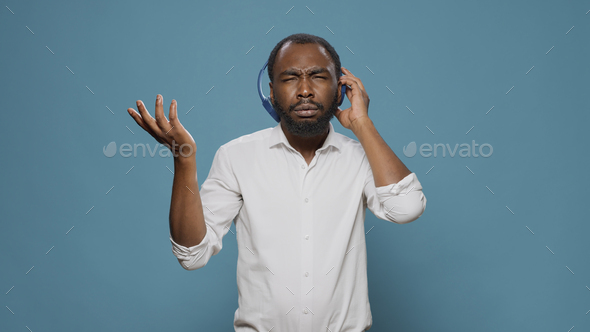 Cool happy man listening to stereo music on audio headset
