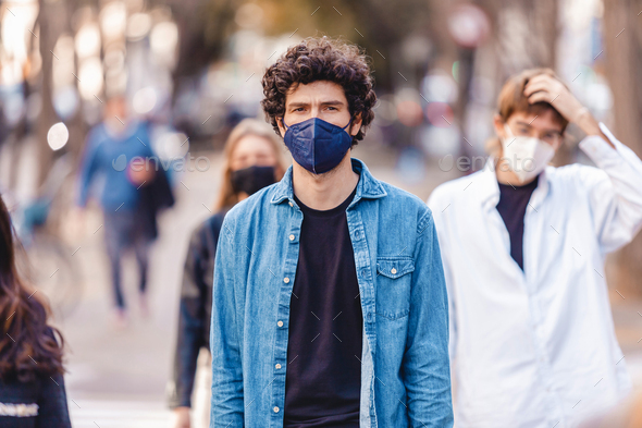 Separated people walking on the street wearing protective face mask