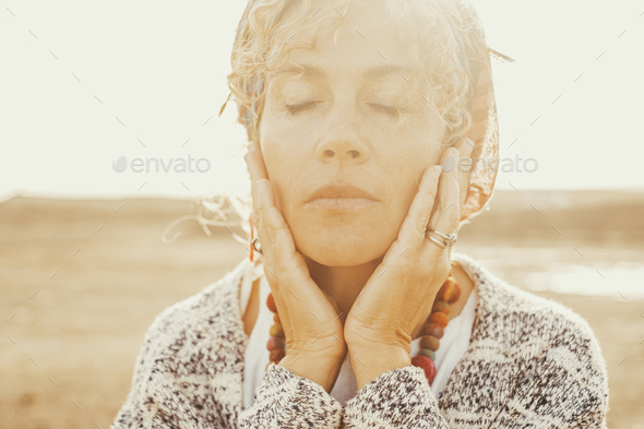 Portrait of adult woman with closed eyes and hands on face. Love and feeling emotions concept