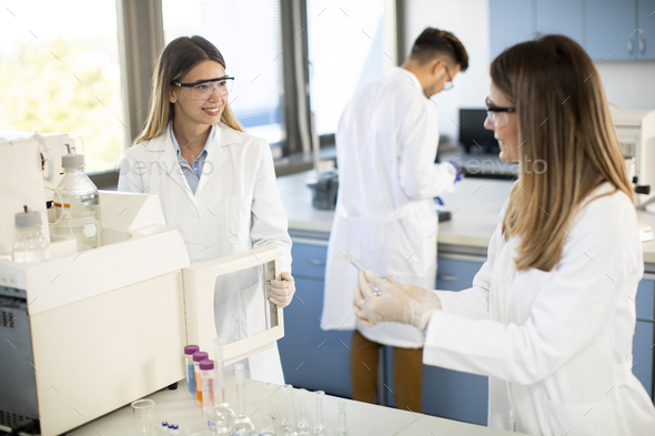 scientists in a white lab coat putting vial with a sample for an analysis - Stock Photo - Images