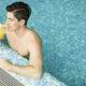 Young man with a drink relaxing in the pool - PhotoDune Item for Sale