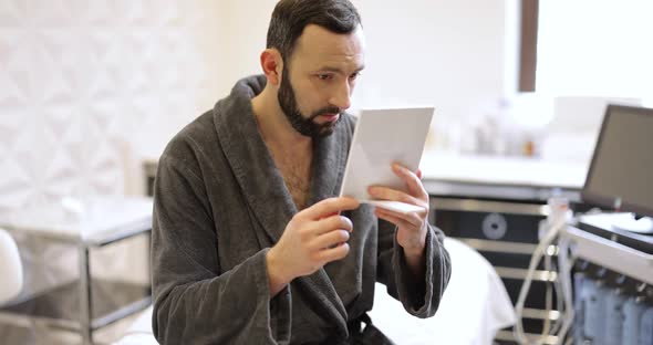 Man Looking at His Face in a Beauty Salon alt