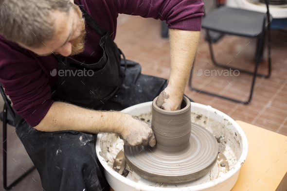 Artist makes clay pottery on a spin wheel