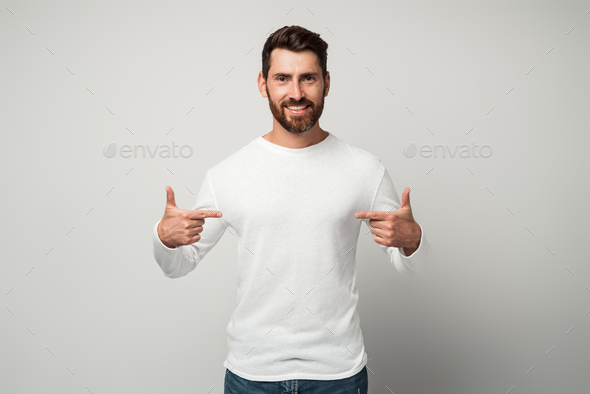 Self-confident narcissistic man smiling satisfied and pointing himself