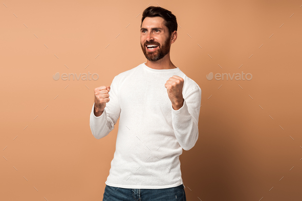 Ecstatic brunette man with beard showing yes i did it gesture