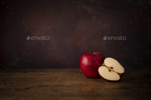 One Whole Apple and One Half Apple on a Wooden Old Surface. Kitchen Table Concept - Stock Photo - Images