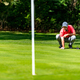 Young golfer playing golf on a beautiful sunny day, reading green - PhotoDune Item for Sale