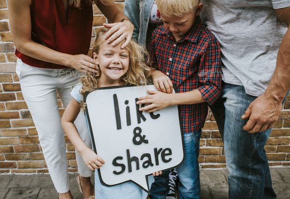 Family holding a like and share sign
