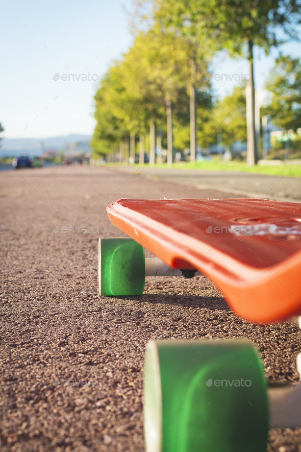 Penny skateboard with green wheels on red asphalt to skate. Stock Photo