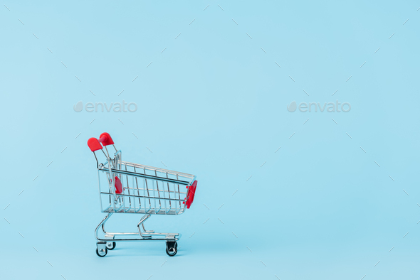 empty toy shopping cart on blue with copy space, leasing concept - Stock Photo - Images