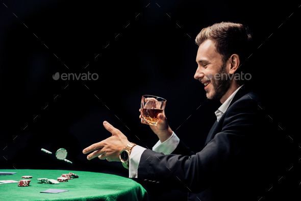 happy man throwing in air poker chips isolated on black
