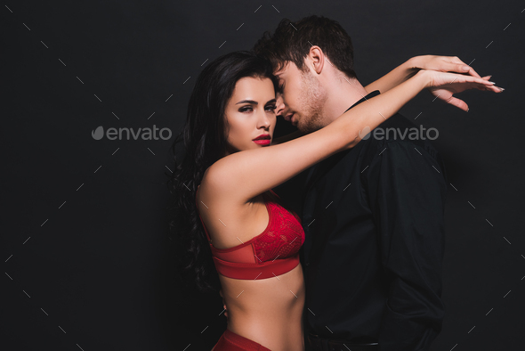 sexy woman in red bra and panties hugging handsome man isolated on black  Stock Photo by LightFieldStudios