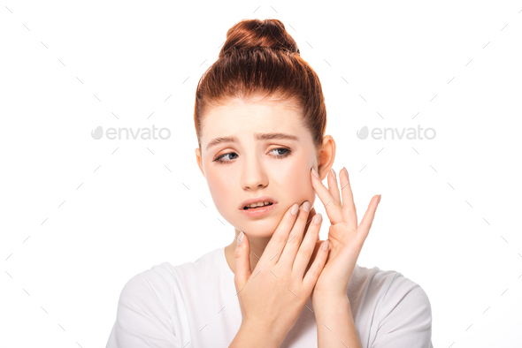 upset teen girl with pimple on face, isolated on white