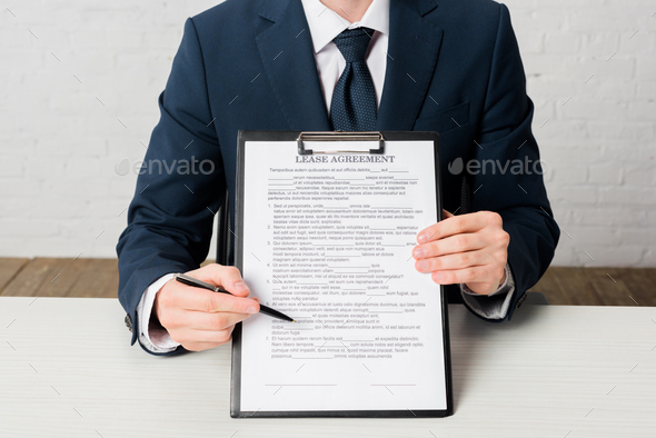 cropped view of realtor holding clipboard with lease agreement lettering on document - Stock Photo - Images