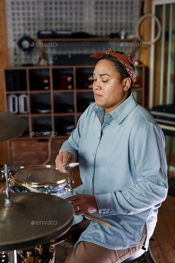 Woman Playing Drums in Studio
