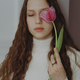 Portrait of a young girl with closed eyes, long hair and a tulip flower - PhotoDune Item for Sale