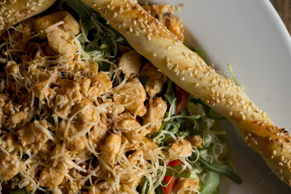 Chicken salad with rocket, cherry tomatoes, smoked cheese and crunchy sesame sticks