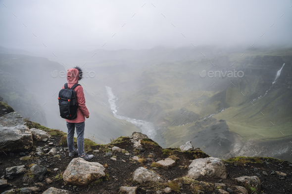Close up of a woman with backpack enjoying icelandic highland and river fossa close to Haifoss - Stock Photo - Images