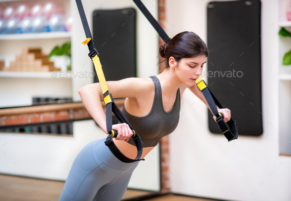 Young woman doing chest press exercises on Trx bands Stock Photo by  Photology75