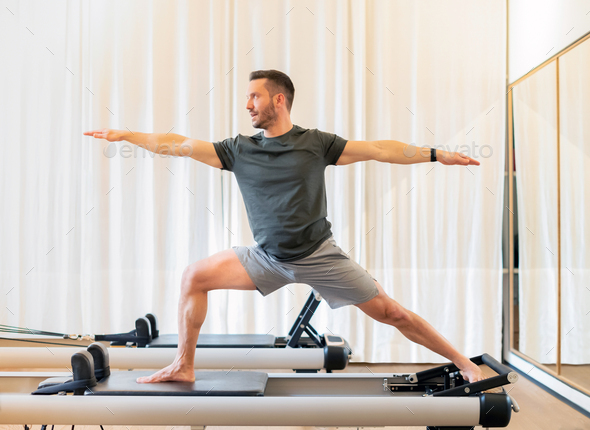 Athletic sporty man doing a yoga balance pose Stock Photo by Photology75