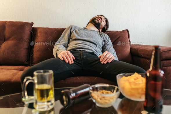 Drunk young man sleeping on sofa after party at home. Stock Photo by ...