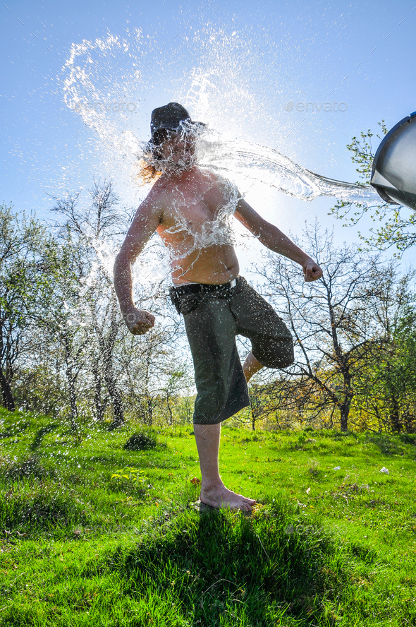 Ice bucket challenge. Man pours iced water from a bucket Stock Photo by salajean