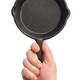 Hand holding empty black cast-iron frying pan - PhotoDune Item for Sale